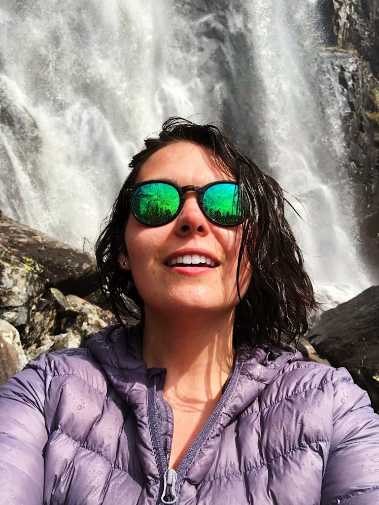 Woman taking a selfie beside a waterfall
