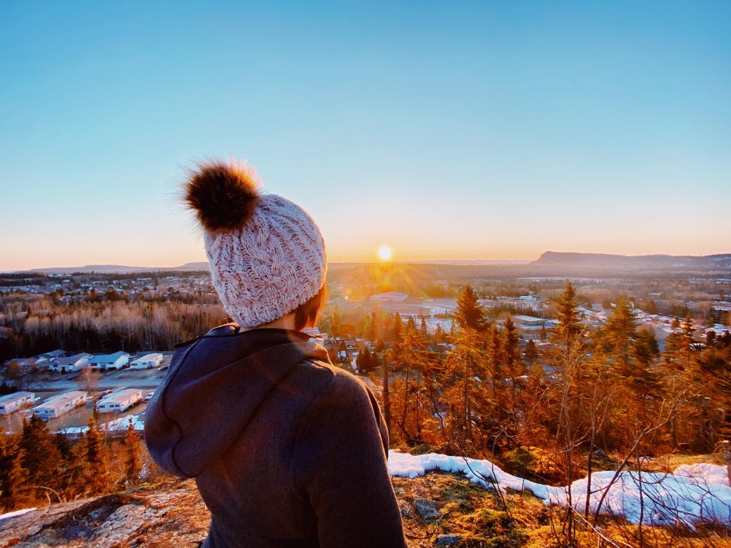 Person overlooking a lake at sunrise